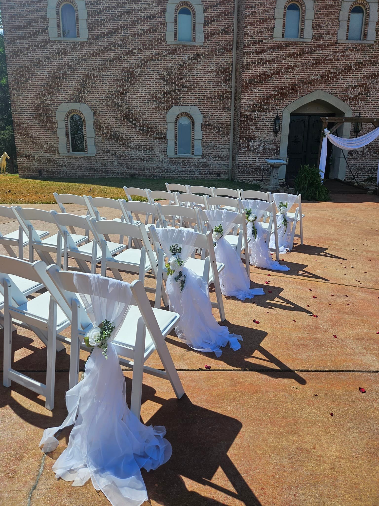 white chairs with white sashes for wedding ceremony